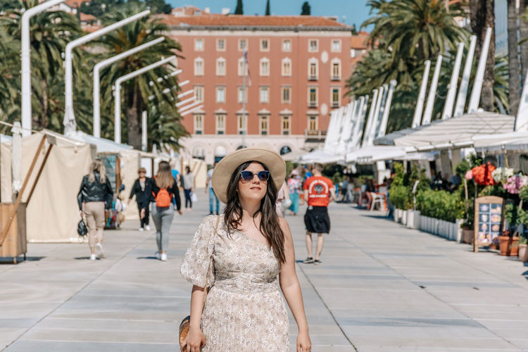 Portrait of young woman walking on riva promenade in city of split in croatia