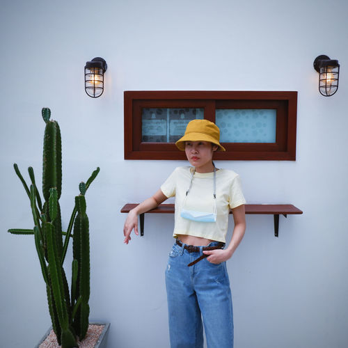 An asian woman standing against white wall on the long vacation
