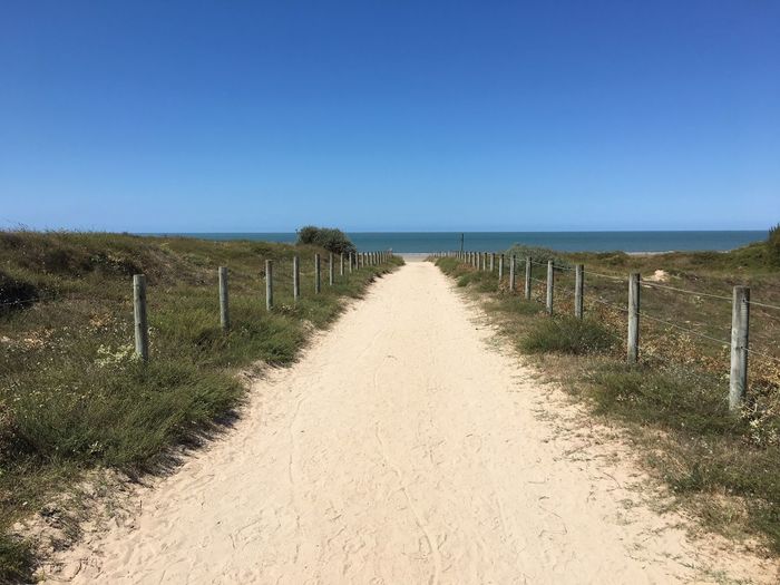 Scenic view of beach against clear blue sky