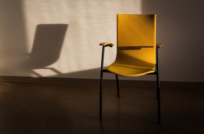 Close-up of yellow chair on table at home