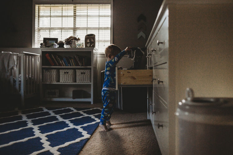 Side view of boy standing at home