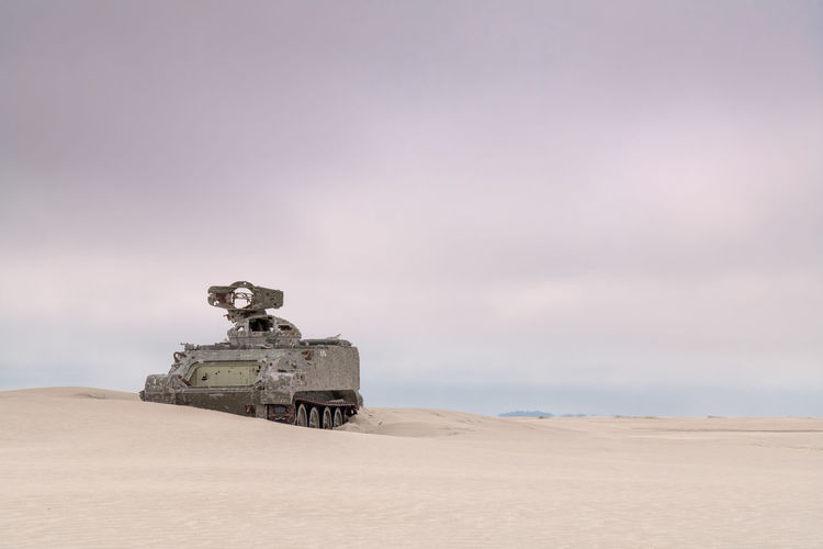 Army tank with bullet holes on the beach