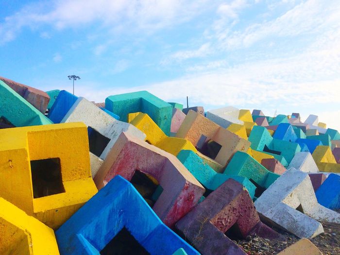 Multi colored concrete blocks against sky