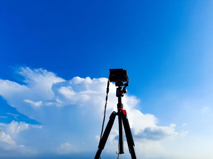 Low angle view of camera against blue sky