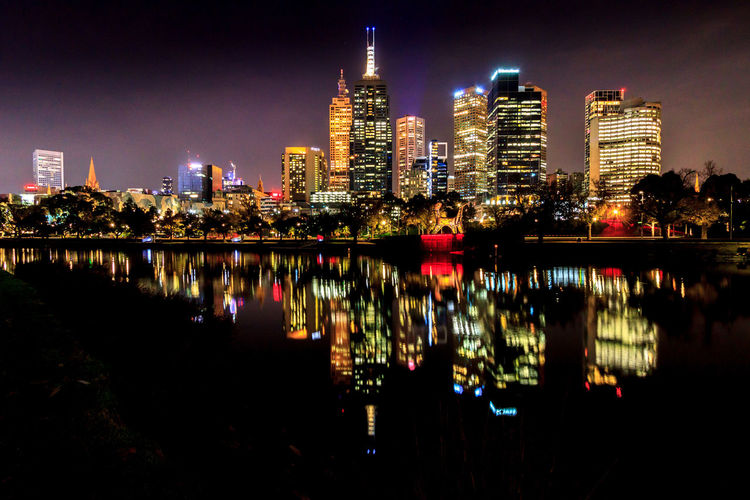 Reflection of illuminated buildings in yarra river of melbourne city at night