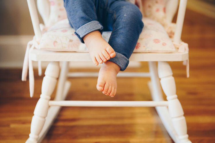 Low section of child sitting on chair