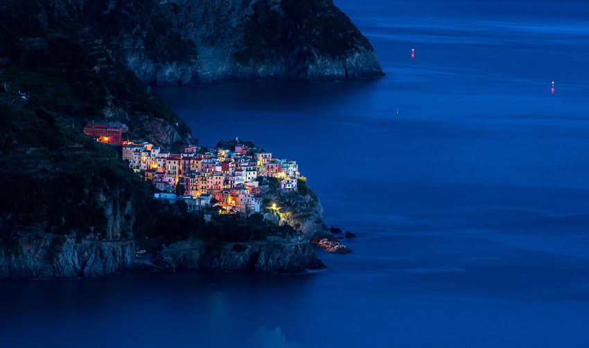 Manarola by night. village of  cinque terre, italy, illuminated at night and mediterranean sea