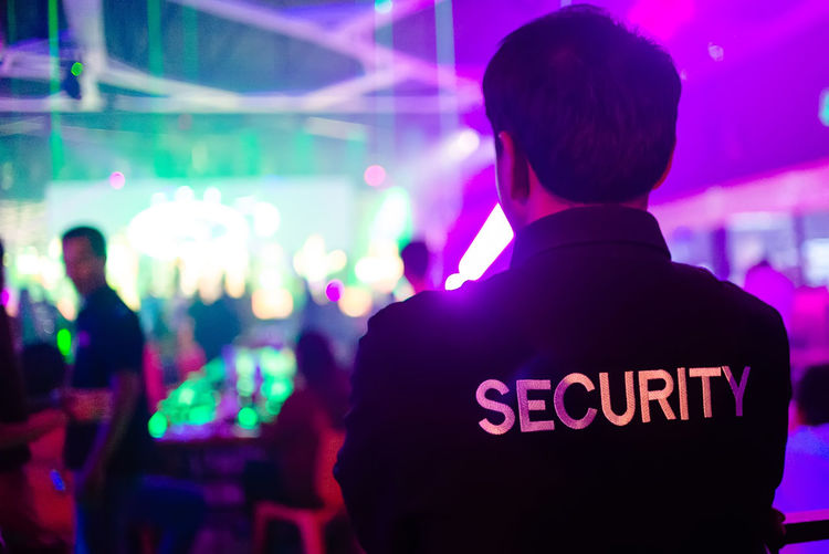 Rear view of security guard at music concert
