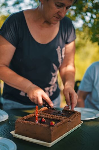 Senior woman cutting birthday cake