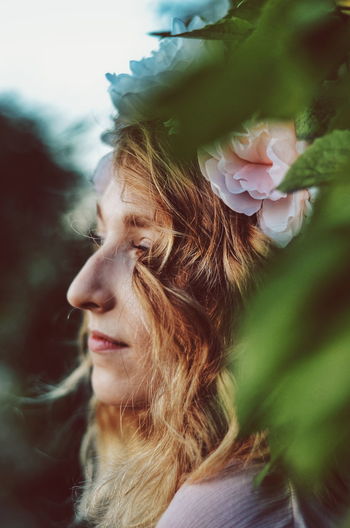 Close-up of thoughtful woman wearing flowers