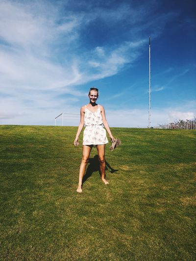 Full length of woman standing on field against sky