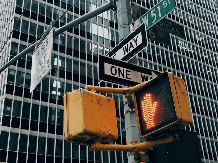 Low angle view of road sign against building