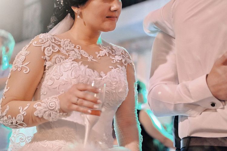 Portrait of bride holding champagne glass in hand and discussing 