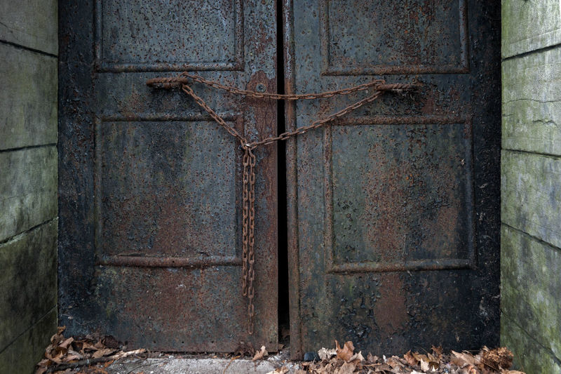 Closed rusty chain on weathered door