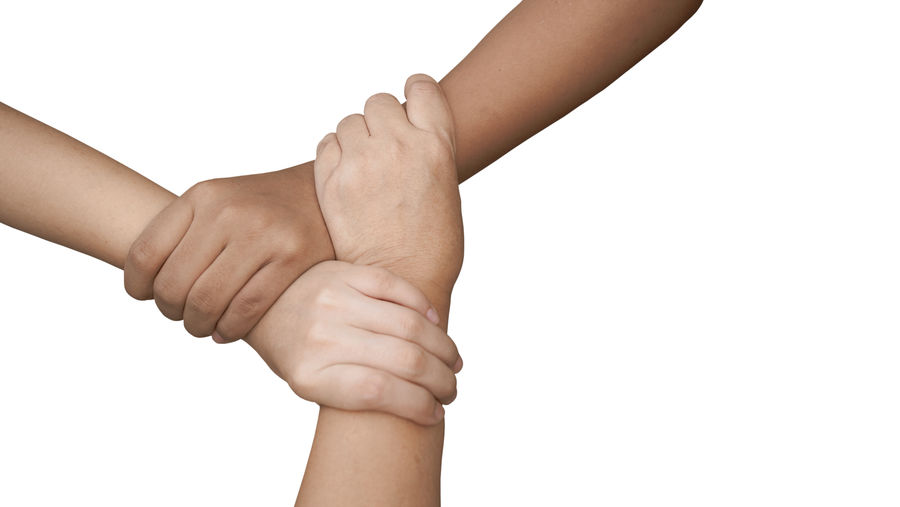 Midsection of couple holding hands against white background