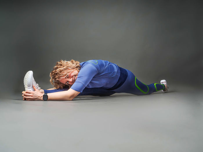 Side view of woman exercising on floor