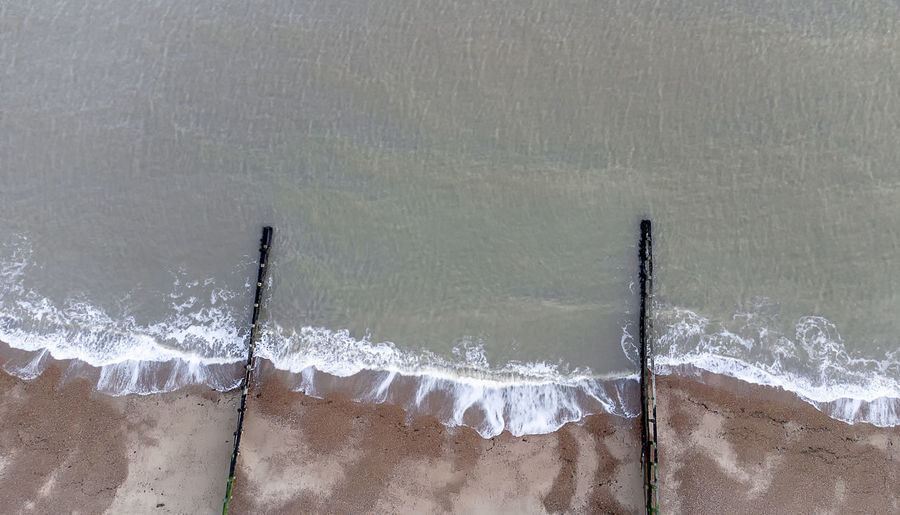 Looking down on waves breaking on a shingle beach in suffolk, uk