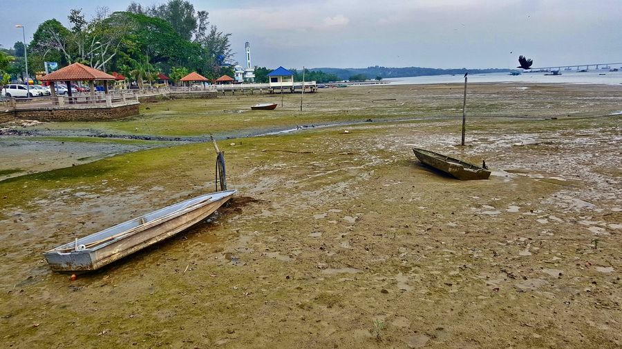 Boats moored on beach against sky