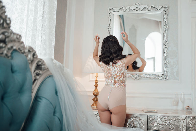 Rear view of woman looking at mirror