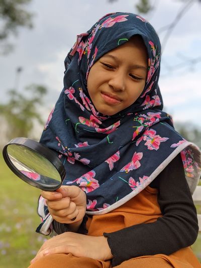 Portrait of a smiling young woman and magnifying glass