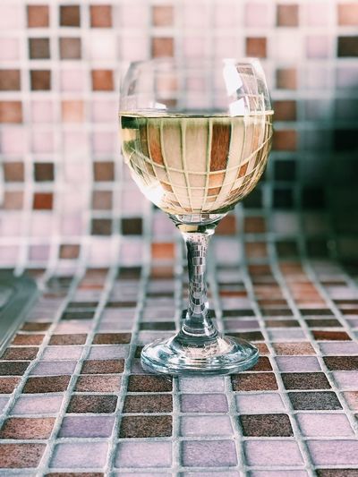 Close-up of wine glass on and in front of mosaic in kitchen 