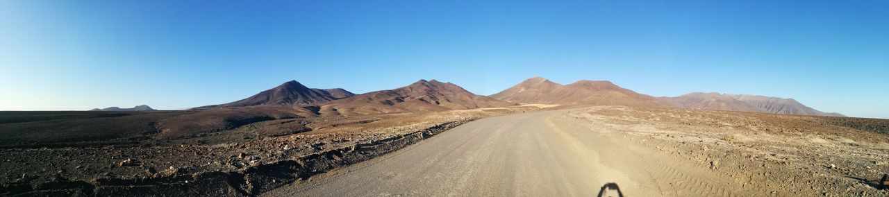 Panoramic view of mountain road against clear blue sky