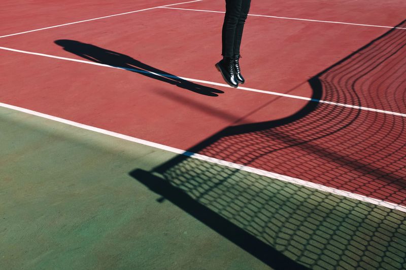 Low section of person jumping on court