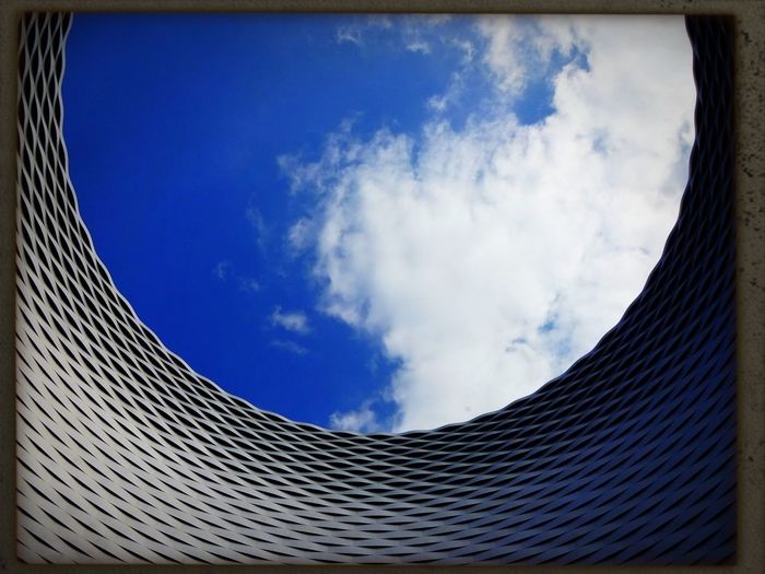 Low angle view of modern building against blue sky