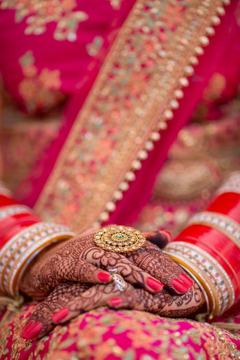 Midsection of bride wearing red traditional clothing