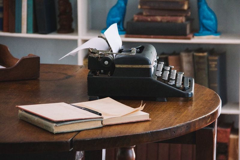 Vintage typewriter by book on table