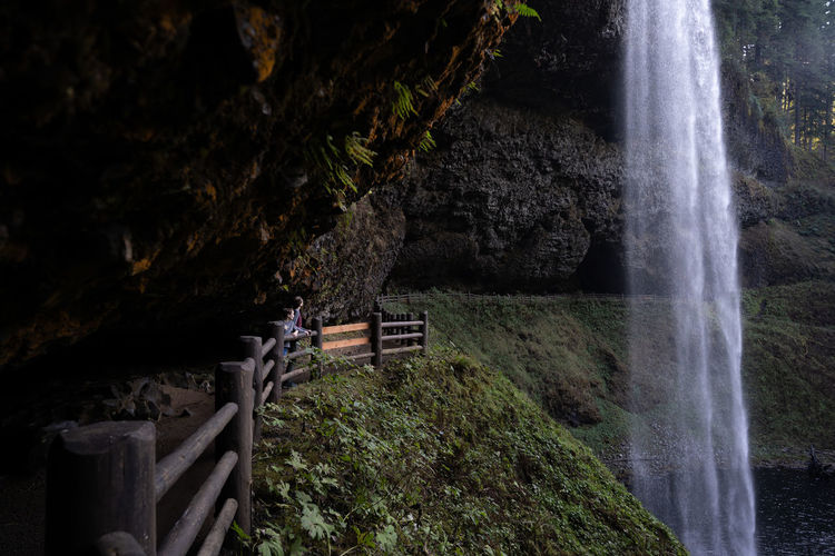 Scenic view of 2 children on trail behind the waterfall at silver falls state park oregon