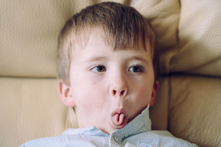 Close-up of boy sticking out tongue