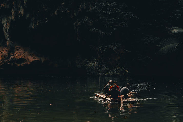 Men sitting on raft in lake