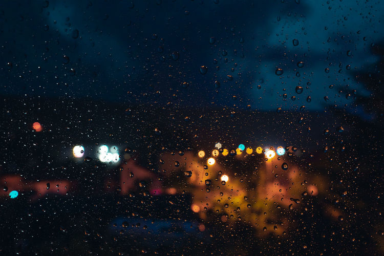 Raindrops on glass window at night