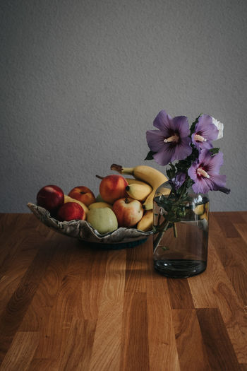 Flowers in bowl on table against wall