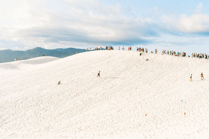 Panoramic view of people on beach against sky