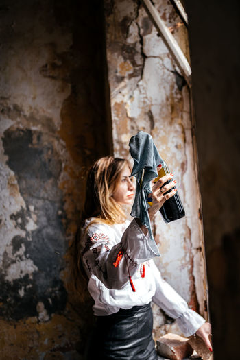 Side view of young woman photographing with camera