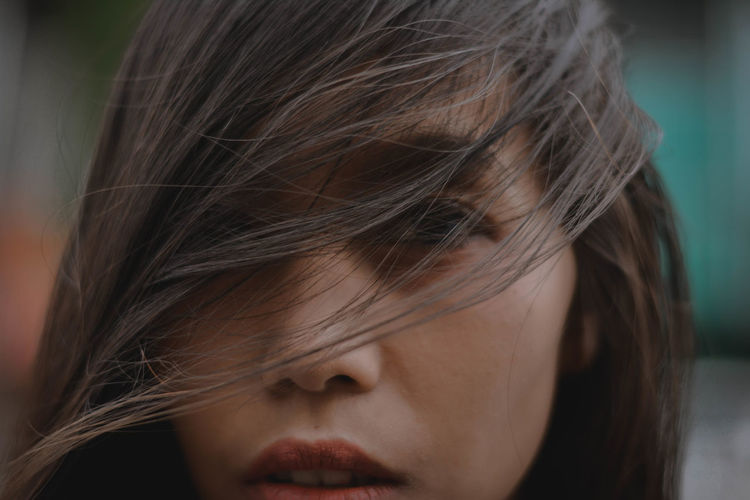 Close-up portrait of woman face covered with hair