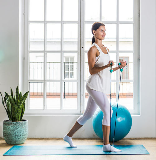 Young woman exercising with fitness ball at home