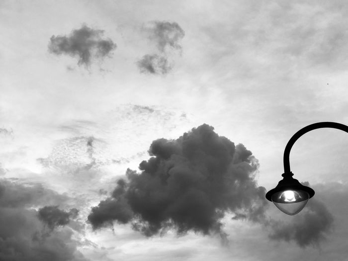 Low angle view of illuminated street light against sky