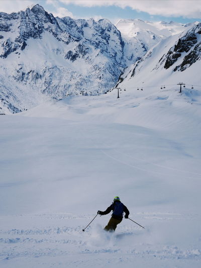 Man skiing against snowcapped mountain