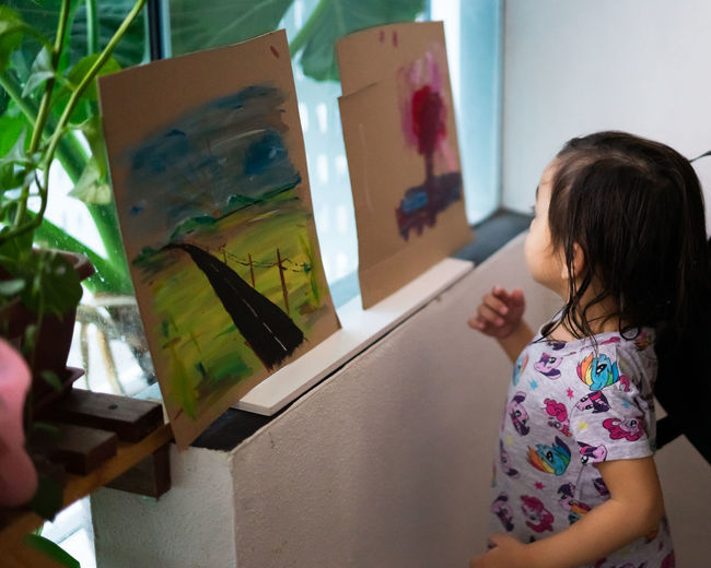High angle view of girl looking at painting