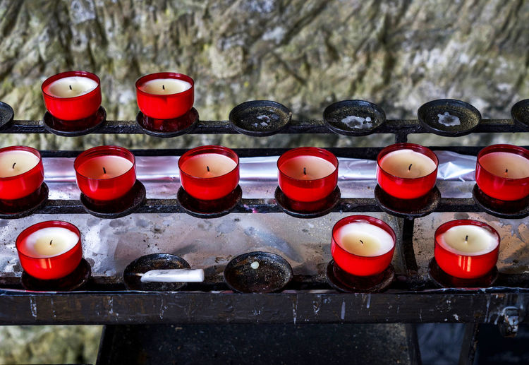 Close-up view of tea light candles on votive stand