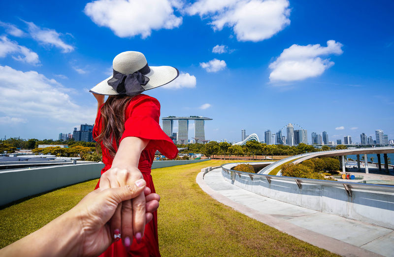 Cropped image of man holding hands with woman in city