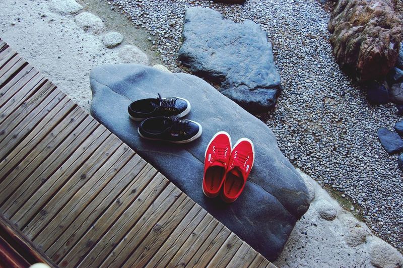 Directly above shot of black and red shoes on rock