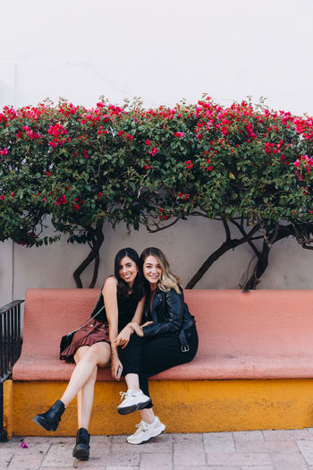 Portrait of women sitting on a bench talking 