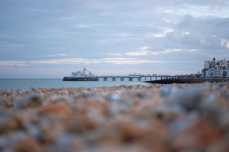 A low-angle view across eastbourne beach towards its landmark victorian pier.