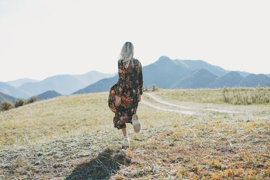 Rear view of woman walking against sky