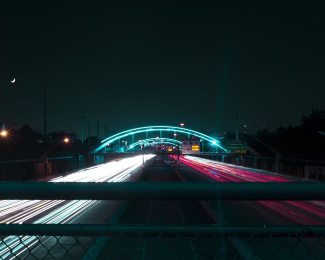 Light trails in city against sky at night