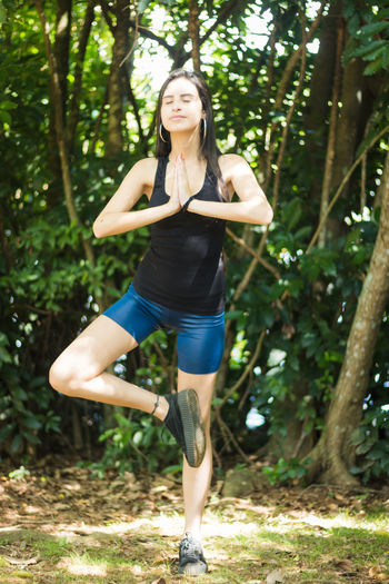 Young woman doing yoga in forest